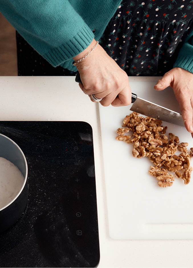 Kate chops walnuts to make brittle for the carrot cake