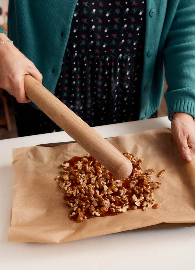Kate uses a rolling bin to break up the brittle for the carrot cake